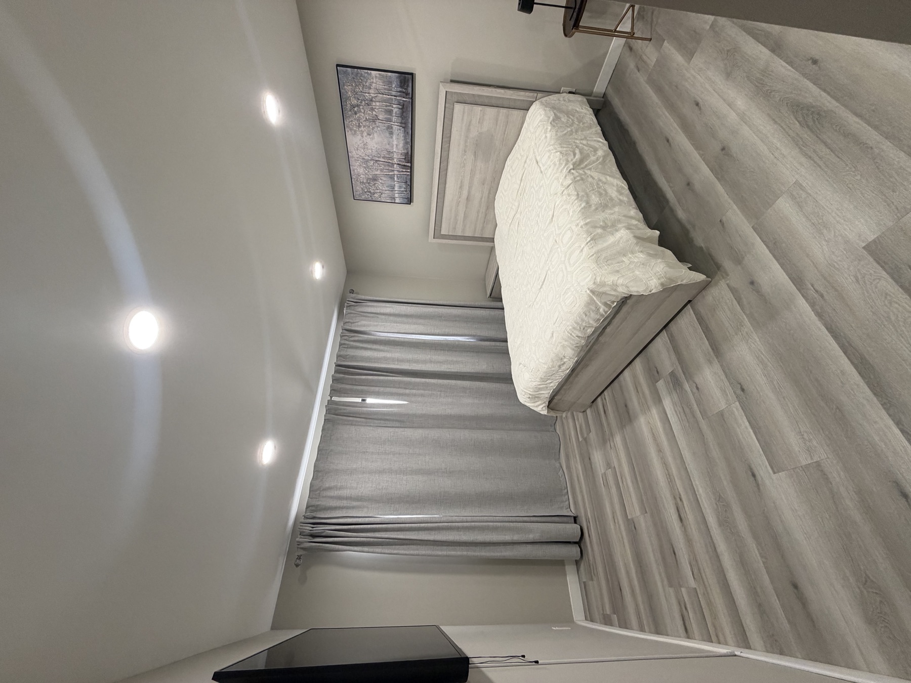 Calm bedroom with queen bed and wood floors